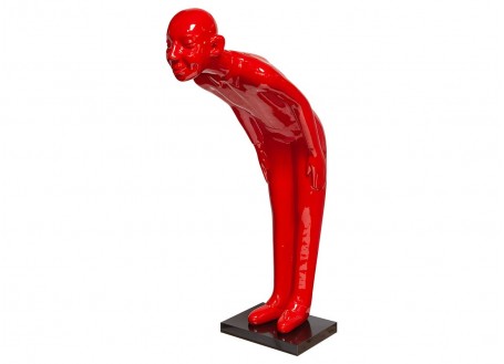 Grande statue rouge d'un bébé au sourire, le pouce levé